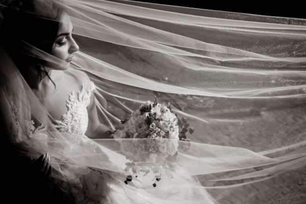 monochrome-view-tender-beautiful-bride-with-wedding-bouquet-long-veil-with-closed-eyes